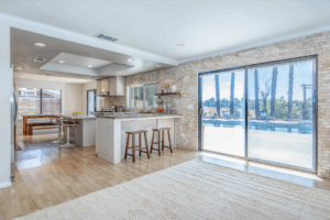 6 Wide shot of dining area that leads into the kitchen with barstools, wood flooring, and granite countertops, tyler media works, real estate photography