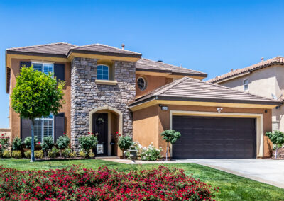 Front of a home showing entry way with green grass and a blue sky in the background, tyler media works, real estate photography