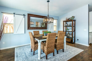 10 Dining area with custom chandelier, wicker chairs, mirror, and wood floors