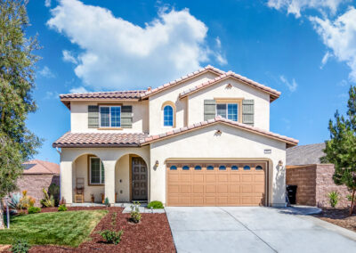 Front of a home showing entry way with green grass and a blue sky in the background, tyler media works, real estate photography