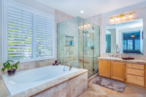 12 Bathroom with tile jacuzzi tub, wood cabinets, and all glass shower
