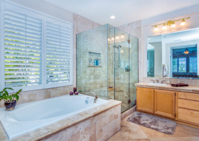 Bathroom with tile jacuzzi tub, wood cabinets, and all glass shower, tyler media works, real estate photography