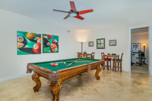 13 Pool table room with 2 bar tables and chairs, with pool ball artwork on the walls