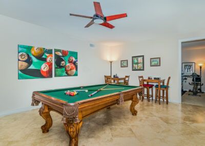 Pool table room with 2 bar tables and chairs, with pool ball artwork on the walls, tyler media works, real estate photography