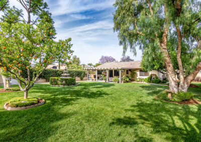 Backyard with large green grass area surrounded by trees, tyler media works, real estate photography
