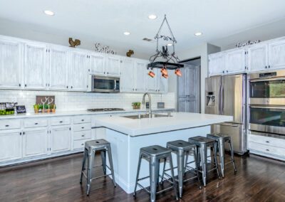Kitchen with rustic white cabinets, white granite countertops, and stainless steel appliances, tyler media works, real estate photography