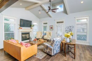 24 Living room with wood flooring, beige chairs, an orange leather loveseat, and a ceiling fan, tyler media works, real estate photography