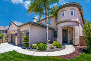 4 Front of a home showing entry way with green grass and a blue sky in the background