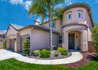 Front of a home showing entry way with green grass and a blue sky in the background, tyler media works, real estate photography