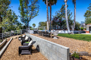 25 Backyard seating area with gravel ground, surrounded by trees