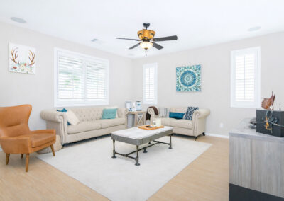 Living room with white couches and ceiling fan, tyler media works, real estate photography