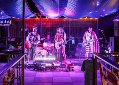 band playing music on deck at night with blue and purple lights