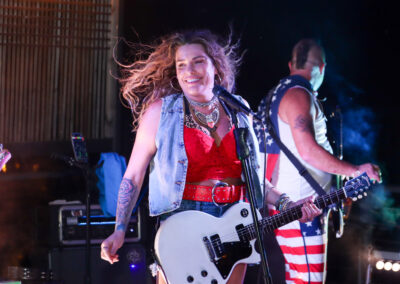 woman playing guitar in band at night